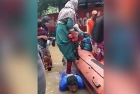 বন্যার পানিতে হাঁটু গেড়ে উবু হয়ে নৌকায় নারীদের পারাপারের অনন্য দৃষ্টান্ত এক জেলের!