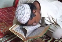 হাত নেই, মুখ দিয়ে পৃষ্ঠা উল্টিয়ে অবিরাম পড়ে চলেছেন পবিত্র কোরআন!