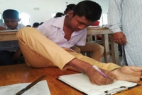 হাত না থাকায় পা দিয়ে পরীক্ষা দিচ্ছে অদম্য মেধাবী মানিক