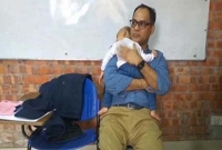 পরীক্ষা দিচ্ছেন মা, সন্তান কোলে বসে শিক্ষক: শিক্ষকের মানবিকতায় আপ্লুত দেশবাসী!