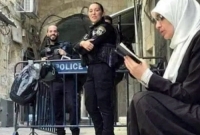 আল আকসা মসজিদের সামনে ইজরায়েলী সেনাদের বাধার মুখেই কুরআন তেলাওয়াত করছে এক সাহসী নারী