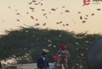 হেলিকপ্টারে করে গ্রামে এসে জনসমক্ষে লাখ লাখ টাকা ওড়াচ্ছেন যুবক