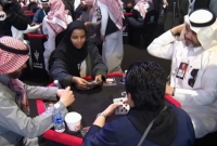 তাস খেলার টেবিলে পুরুষদের সঙ্গে তাস খেলছেন সৌদি নারী