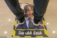 অভিনব এ প্রতিবাদ! ম্যাক্রোঁর ছবির ওপর পা রেখে ক্রেতাদের দাঁড়াতে হচ্ছে