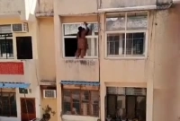 বহুতল ভবণের কার্নিসে দাঁড়িয়ে এ কী করছেন ভয়ডরহীন নারী!